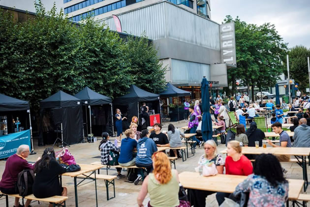People enjoying al fresco dining and drinking in Lyric Square