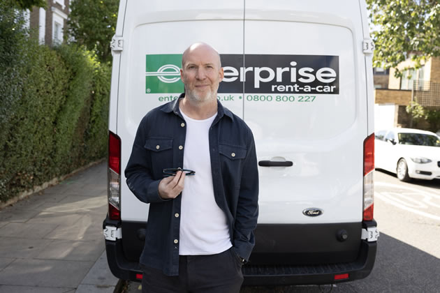 Drew Palmer in front of an Enterprise van parked near his home