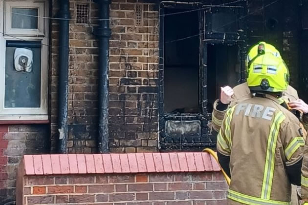 Fire fighters outside the gutted flat in West Kensington