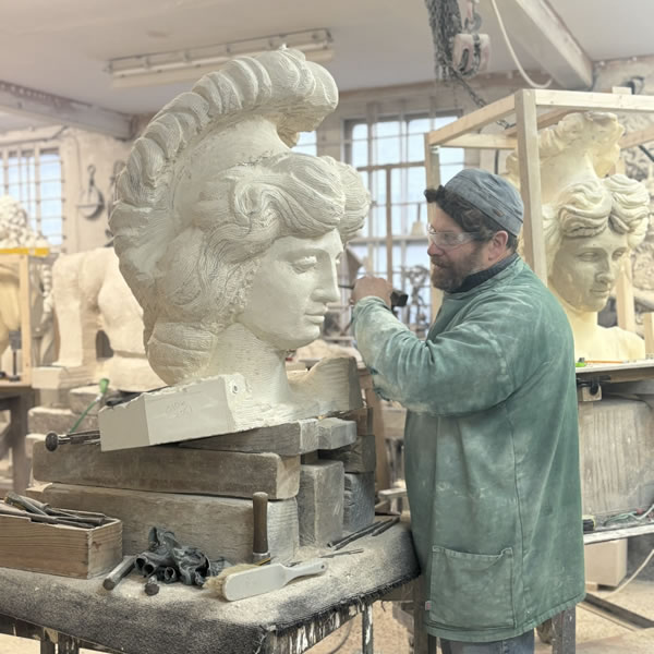 Carver Simon Smith making finishes touches on head of sculpture 